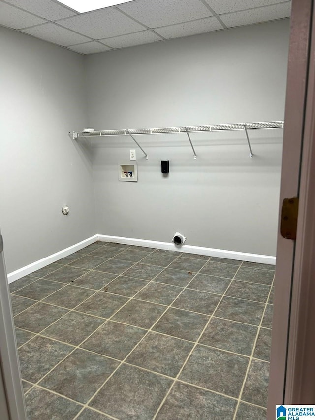 laundry area with laundry area, baseboards, hookup for a washing machine, hookup for an electric dryer, and dark tile patterned floors