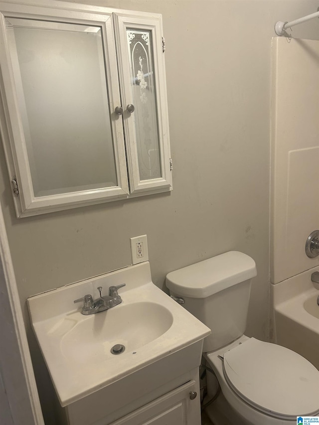 bathroom with washtub / shower combination, vanity, and toilet