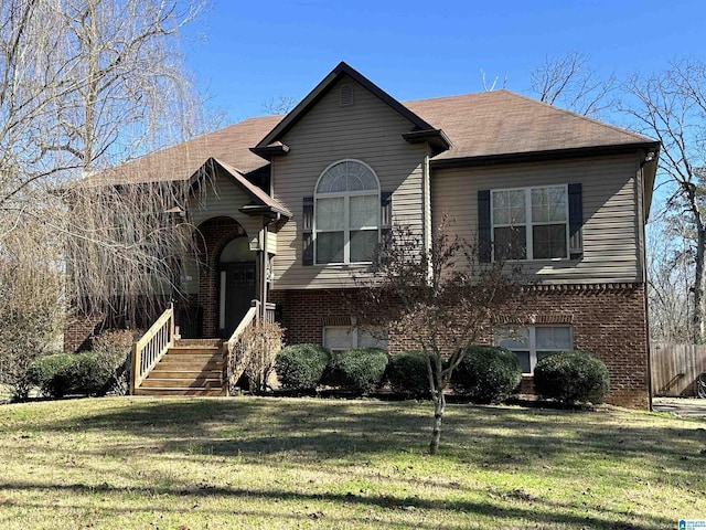 bi-level home with a front yard and brick siding