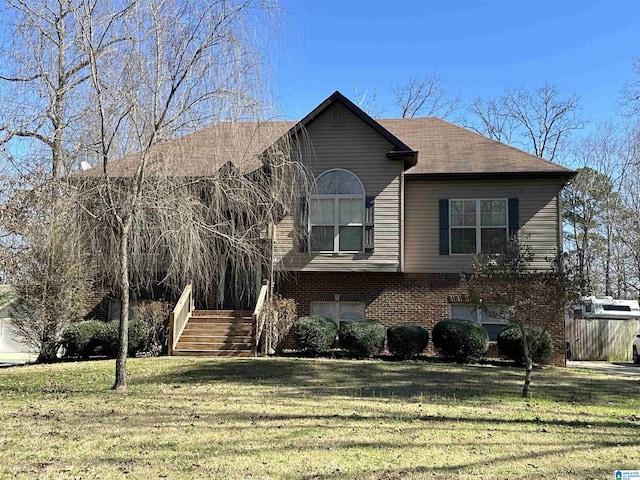 view of front of house featuring stairs, a front yard, and brick siding