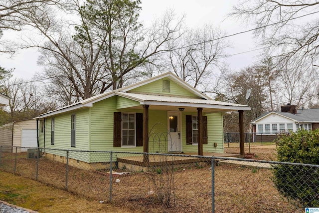 view of front of home featuring crawl space, covered porch, a fenced front yard, and metal roof