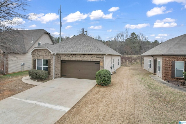 view of front of property with a shingled roof, concrete driveway, brick siding, and an attached garage