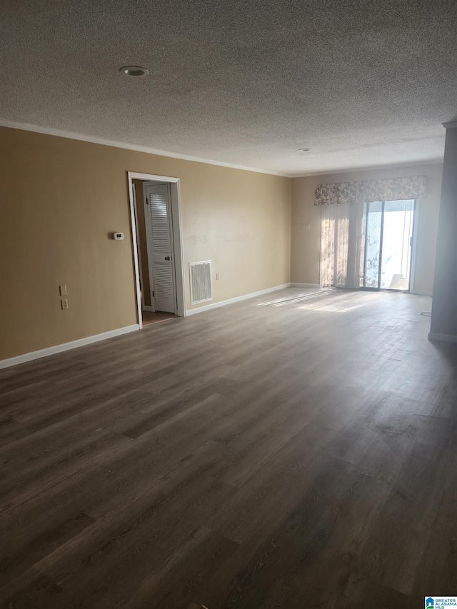 unfurnished room with dark wood-style flooring, crown molding, visible vents, a textured ceiling, and baseboards