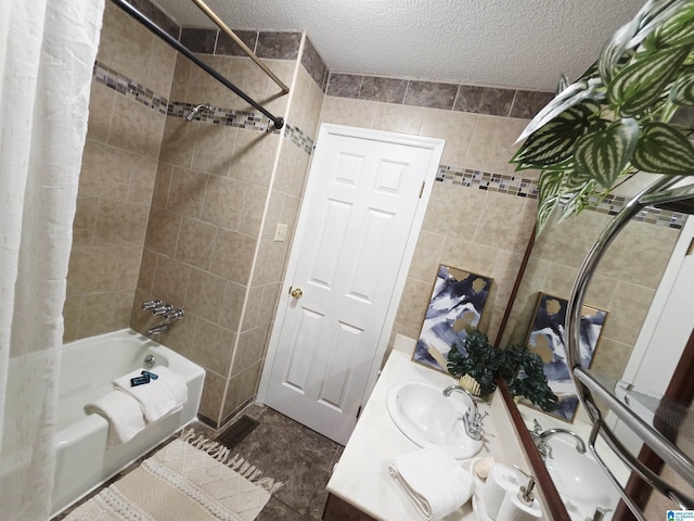 bathroom featuring shower / bath combination with curtain, vanity, a textured ceiling, and tile walls