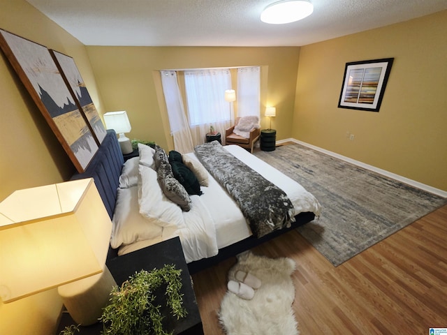 bedroom featuring wood finished floors and baseboards