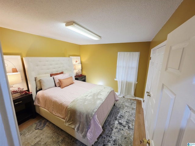 bedroom with wood finished floors and a textured ceiling