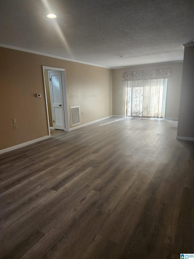 unfurnished room with dark wood-type flooring, visible vents, crown molding, and a textured ceiling