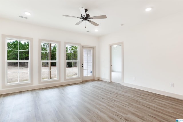 unfurnished room with light wood finished floors, recessed lighting, visible vents, and a healthy amount of sunlight