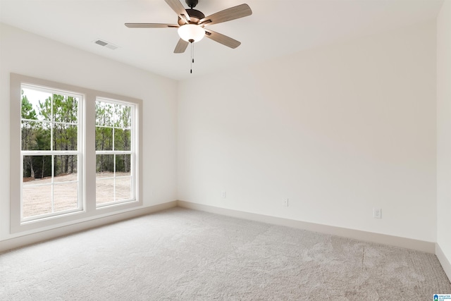 carpeted empty room featuring visible vents, ceiling fan, and baseboards