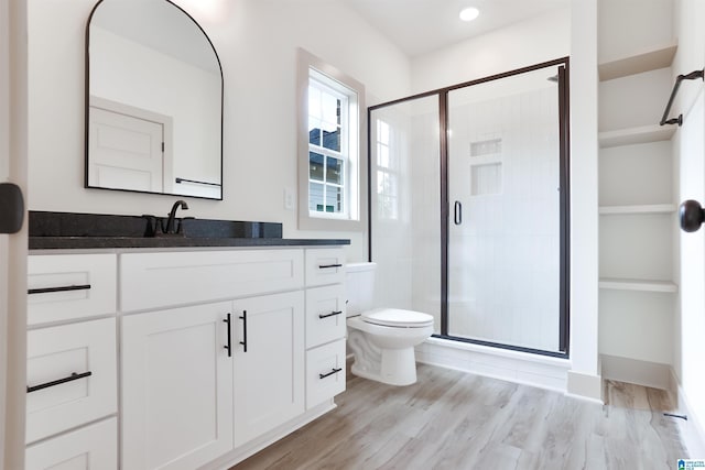 full bath with toilet, recessed lighting, wood finished floors, vanity, and a shower stall