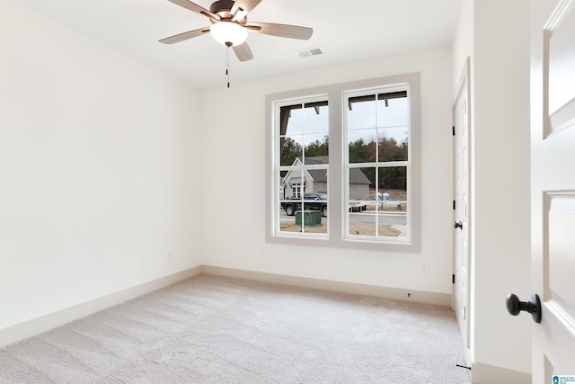 empty room with ceiling fan, baseboards, visible vents, and light colored carpet