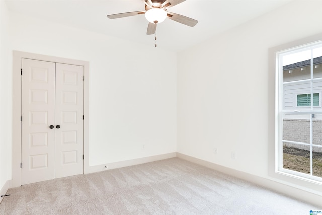 unfurnished room with light carpet and ceiling fan