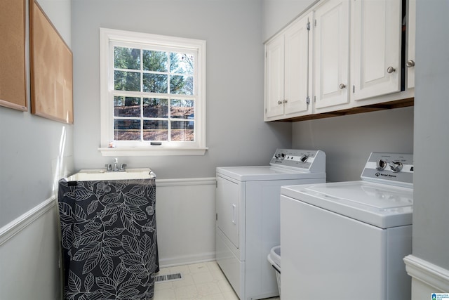 washroom featuring cabinet space, visible vents, separate washer and dryer, and light floors