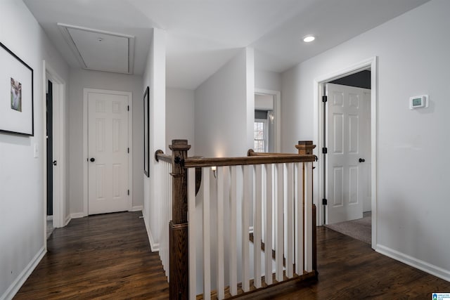 corridor with dark wood-style floors, recessed lighting, attic access, an upstairs landing, and baseboards