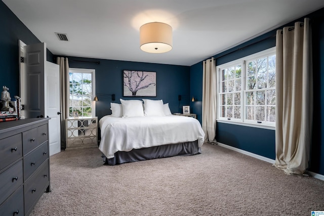 carpeted bedroom featuring visible vents and baseboards