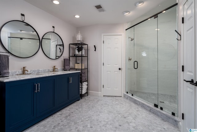 bathroom featuring double vanity, a stall shower, baseboards, visible vents, and a sink