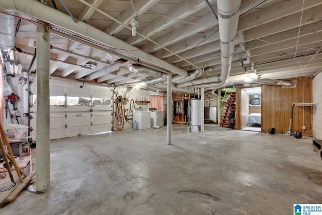 garage featuring water heater and washing machine and clothes dryer