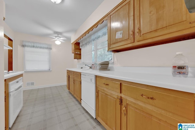 kitchen with baseboards, visible vents, dishwasher, light countertops, and light floors