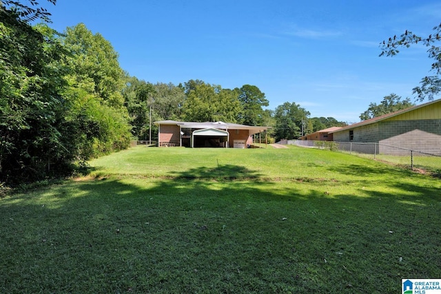 view of yard featuring a carport and a fenced backyard