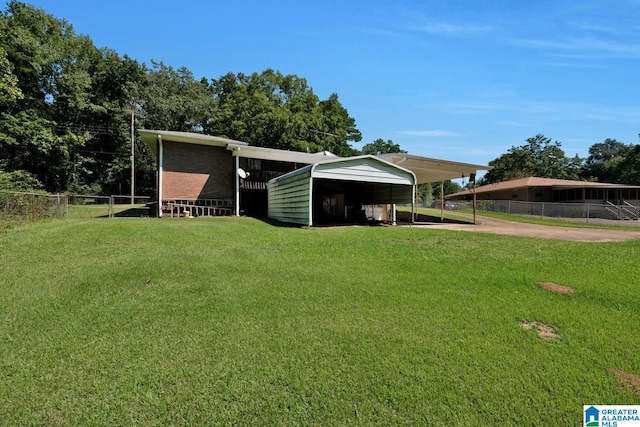 exterior space with a detached carport, brick siding, fence, and a front lawn