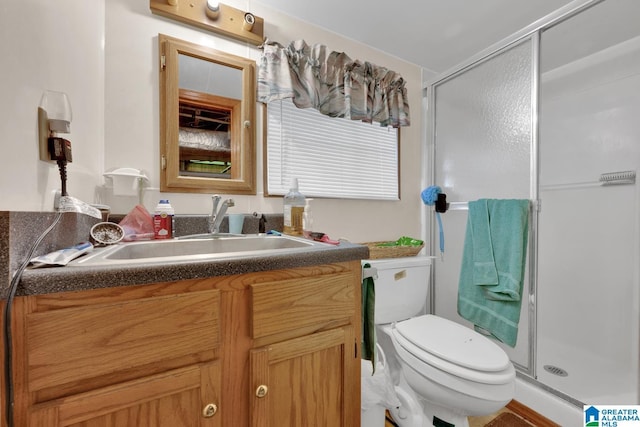 bathroom featuring a stall shower, vanity, and toilet