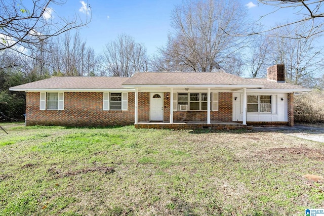 single story home with a porch, brick siding, a chimney, and a front lawn