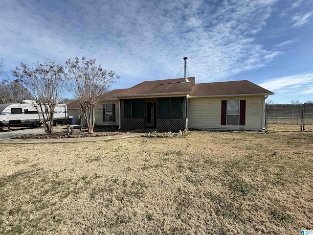 back of property featuring a lawn, fence, and a sunroom