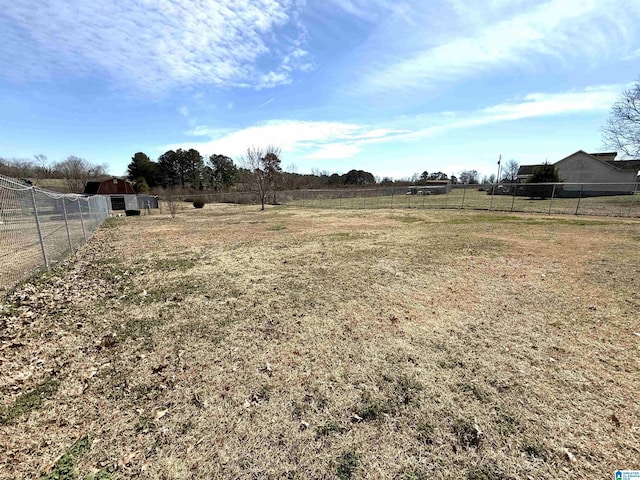 view of yard featuring fence and a rural view