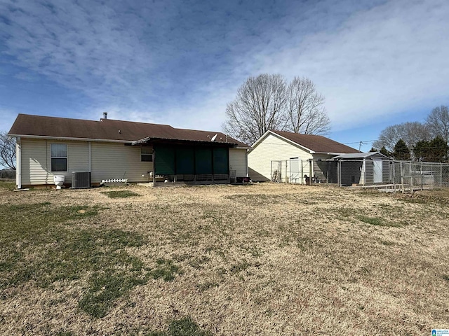 back of property featuring an outbuilding, a yard, and central AC unit