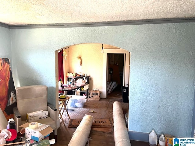 interior space featuring ornamental molding and a textured wall