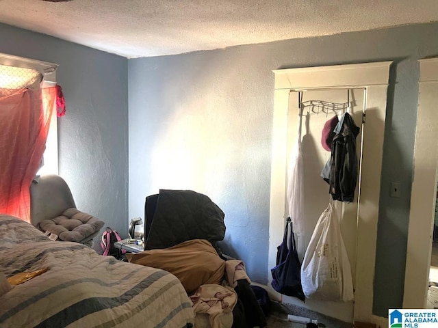 bedroom with a textured wall and a textured ceiling