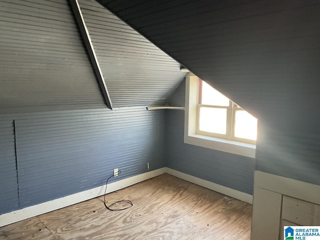 additional living space with lofted ceiling, wood finished floors, and baseboards