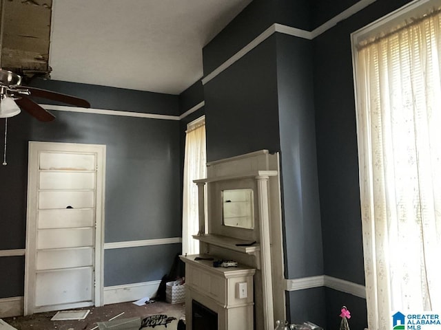 interior space with a healthy amount of sunlight, ceiling fan, and baseboards