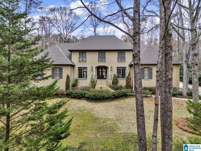 view of front of house with french doors and a shingled roof