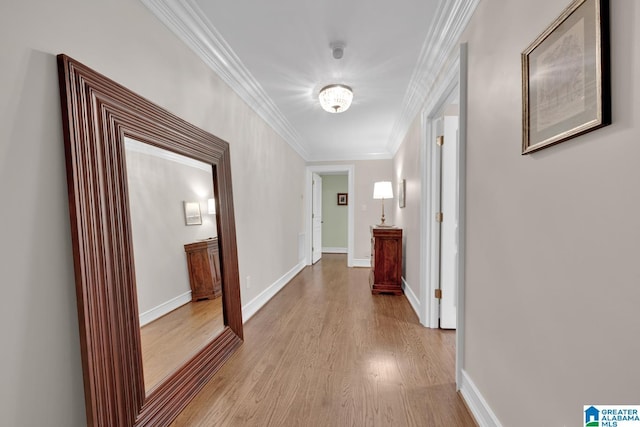 hall with light wood-style floors, baseboards, and ornamental molding