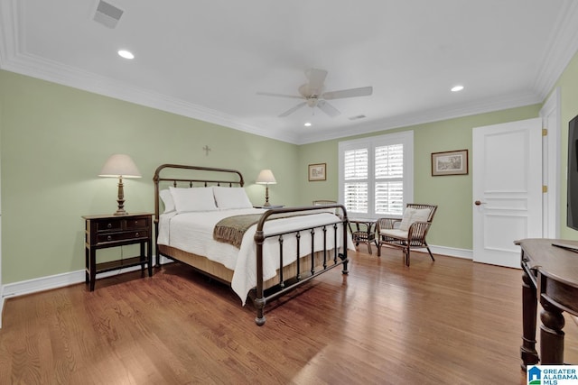 bedroom with recessed lighting, crown molding, baseboards, and wood finished floors