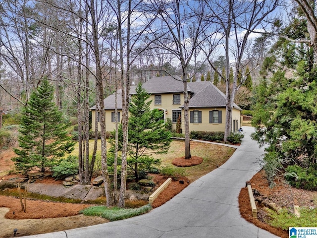 view of front of property featuring concrete driveway, a shingled roof, and stucco siding