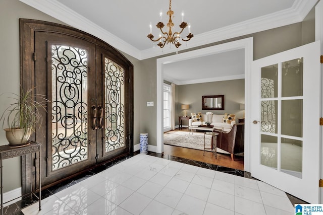 entrance foyer with an inviting chandelier, baseboards, ornamental molding, and french doors