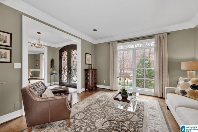 living area featuring french doors, plenty of natural light, wood finished floors, and crown molding