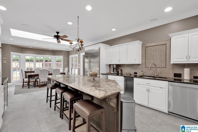 kitchen featuring tasteful backsplash, stainless steel appliances, a sink, and a kitchen breakfast bar