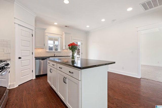 kitchen with visible vents, white cabinets, appliances with stainless steel finishes, a center island, and dark countertops