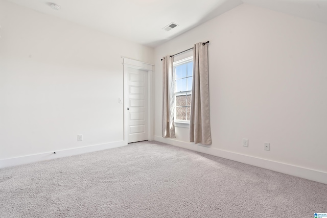 unfurnished room with carpet, visible vents, and baseboards