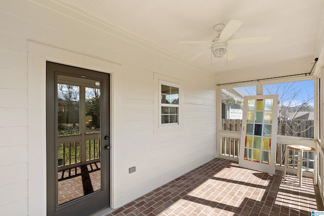 sunroom / solarium featuring a healthy amount of sunlight and ceiling fan