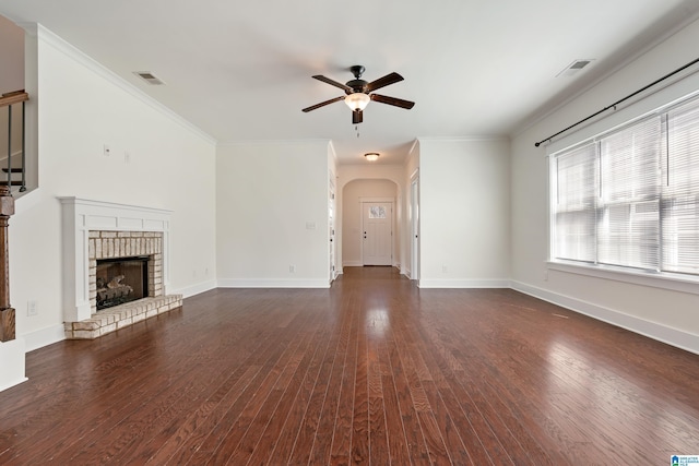 unfurnished living room featuring a fireplace, visible vents, arched walkways, and dark wood-type flooring