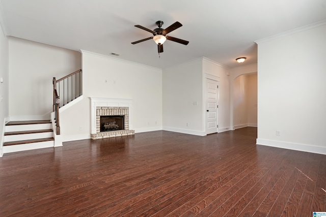 unfurnished living room with visible vents, arched walkways, dark wood-style floors, stairs, and a fireplace