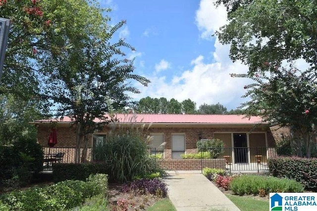 ranch-style house featuring brick siding and fence