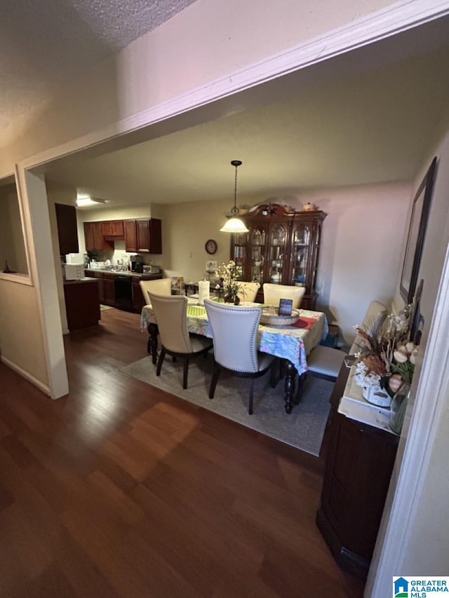 dining space with dark wood finished floors and a textured ceiling