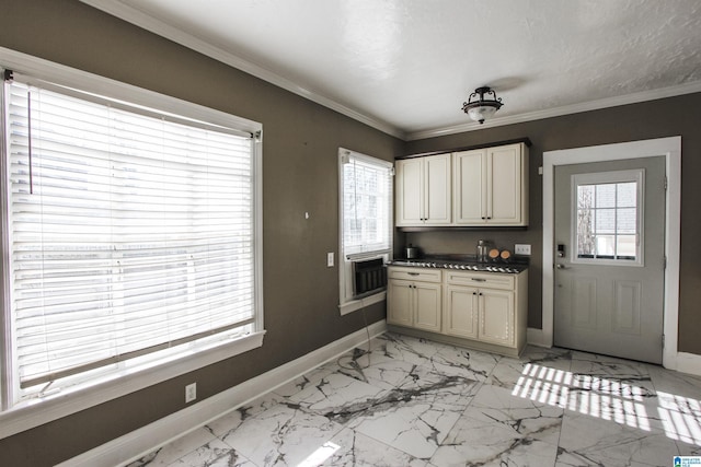 kitchen with dark countertops, marble finish floor, crown molding, and baseboards