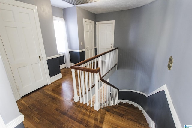 staircase featuring baseboards and wood finished floors