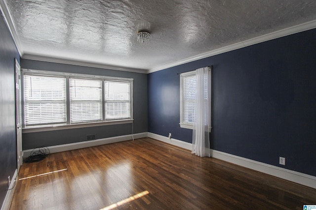 empty room featuring baseboards, visible vents, ornamental molding, dark wood-style flooring, and a textured ceiling